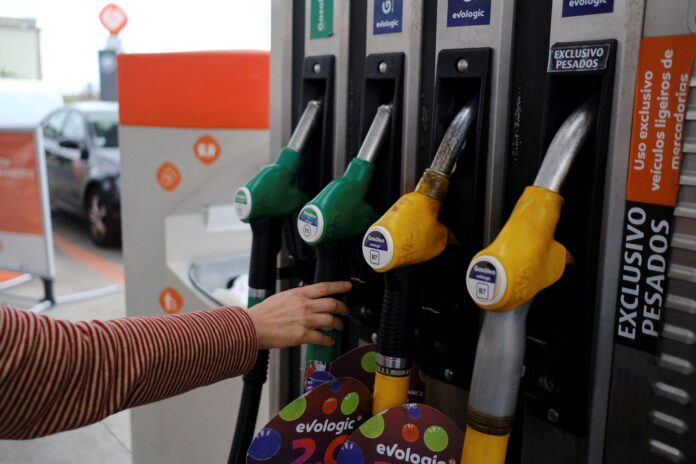 FILE PHOTO: A person uses a petrol pump, as the price of petrol rises, in Lisbon